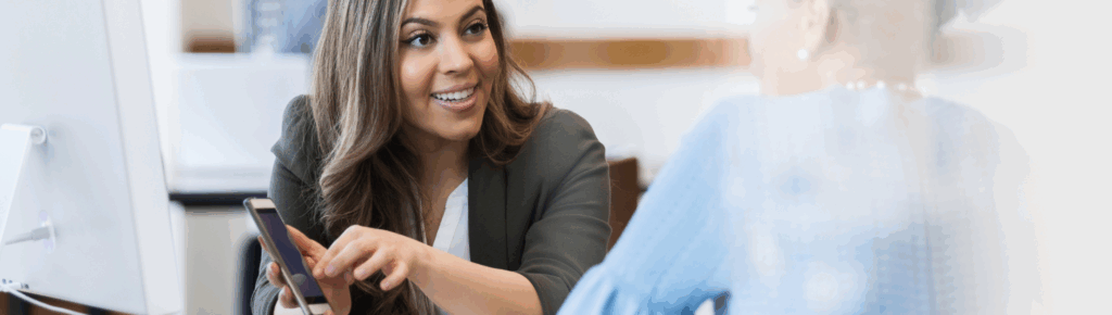 Funcionária do banco ajudando senhora a adquirir sua moeda social