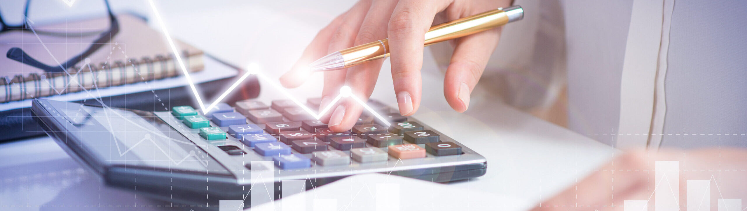 Pessoa usando calculadora com caneta na mão, ao lado de caderno e gráficos, representando análise financeira, planejamento contábil e controle de lucros.