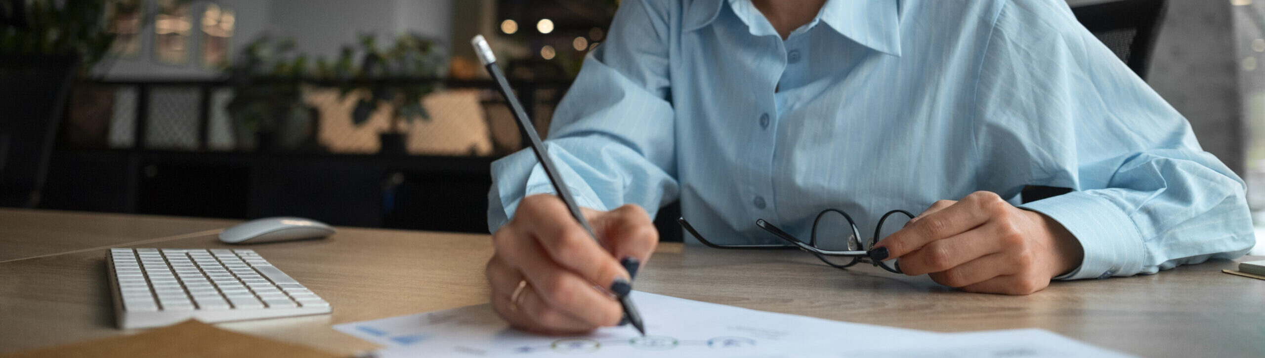 Mulher sorridente analisando gráficos financeiros em escritório moderno.